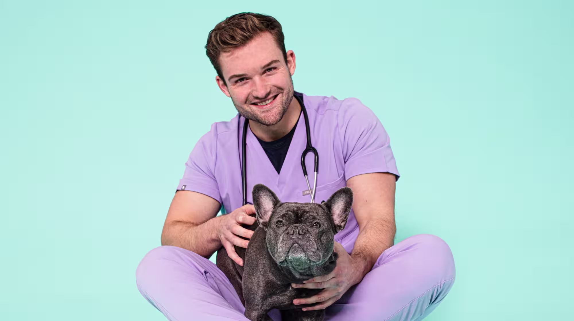 Vet Alex with a french bulldog on a blue background